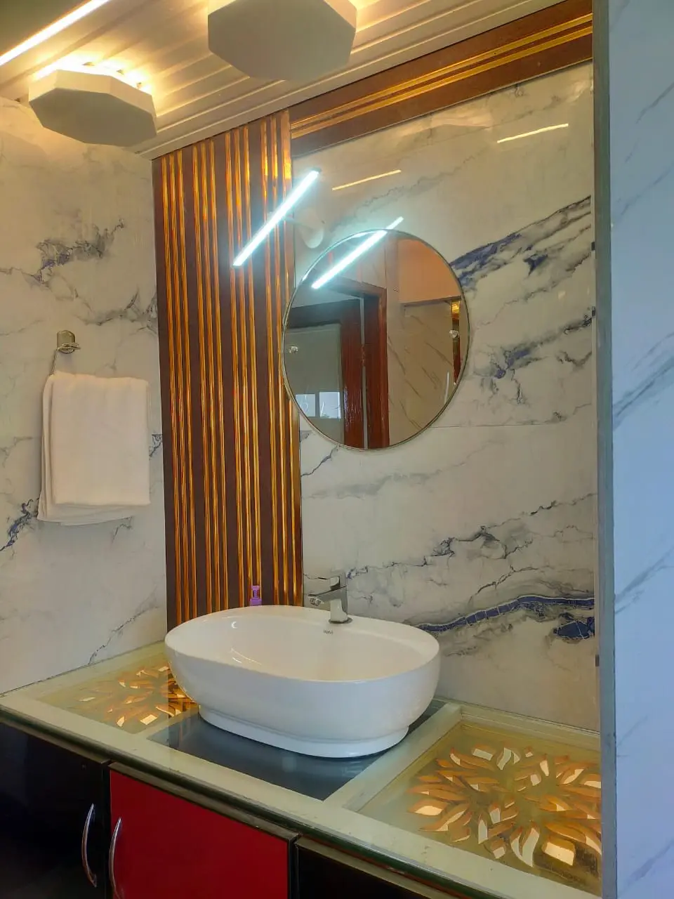 Marble bathroom vanity with vessel basin and round mirror on a premium houseboat