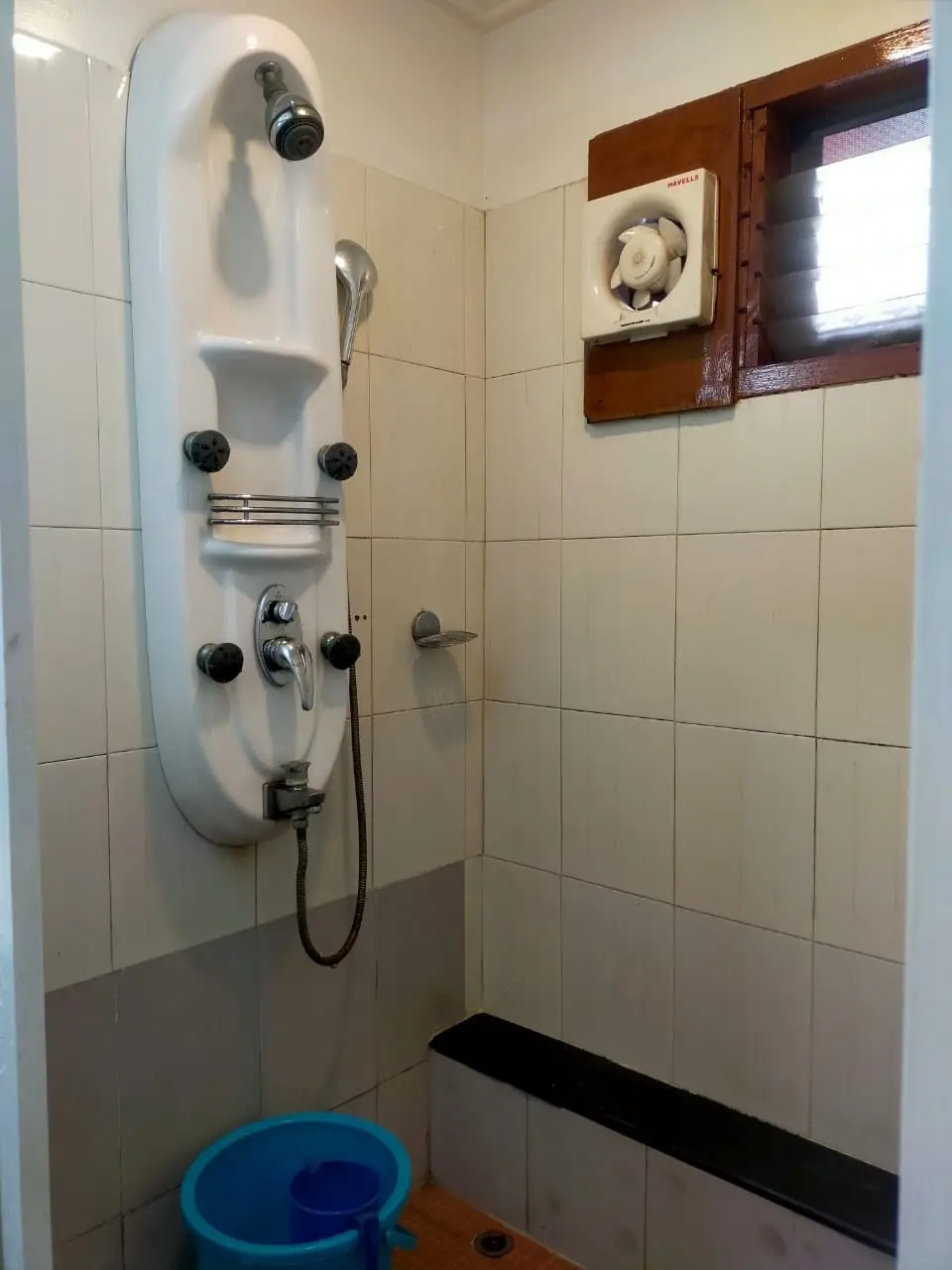 Tiled shower cubicle with overhead rain shower panel on a Kerala houseboat