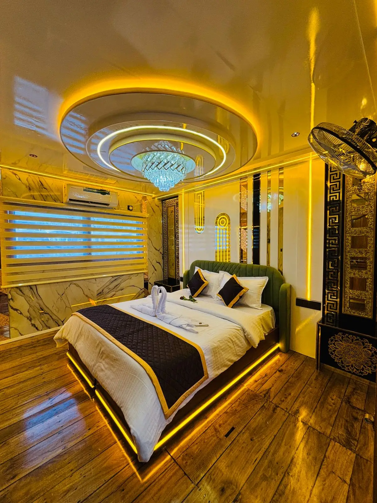 Second emerald-headboard bedroom with chandelier on a luxury houseboat