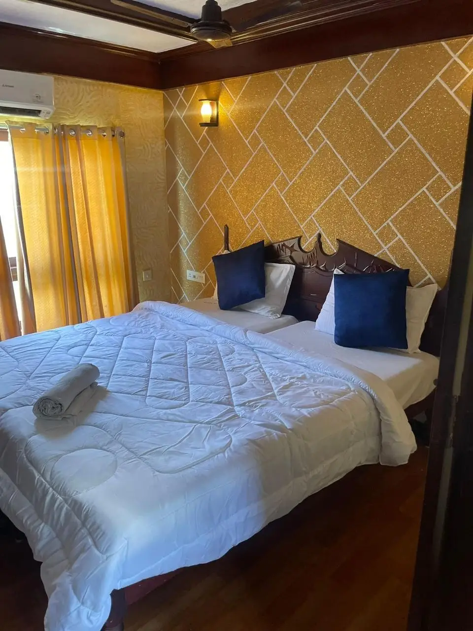 Air-conditioned bedroom with mosaic headboard wall on a six-bedroom houseboat