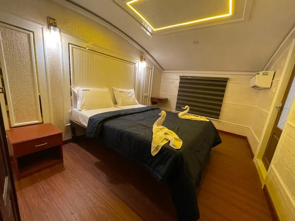 Air-conditioned bedroom with towel swans on an eight-bedroom Kerala houseboat