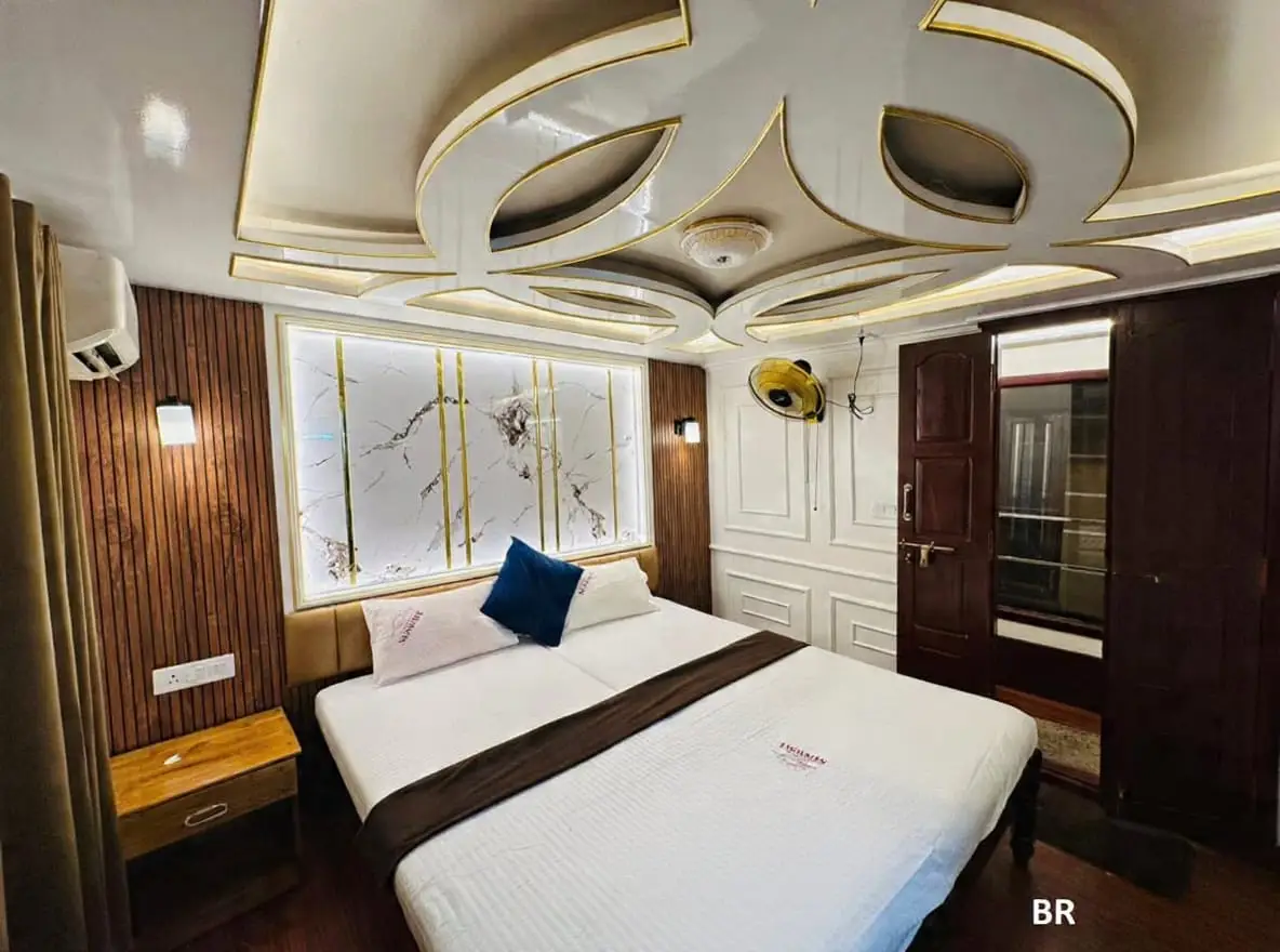 Air-conditioned houseboat bedroom with decorative false ceiling and marble headboard