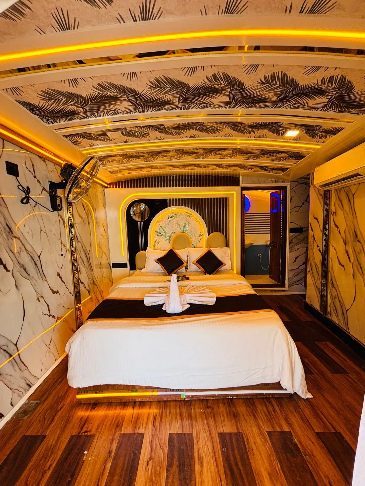 Gold-arched luxury bedroom with printed ceiling on an Alleppey houseboat