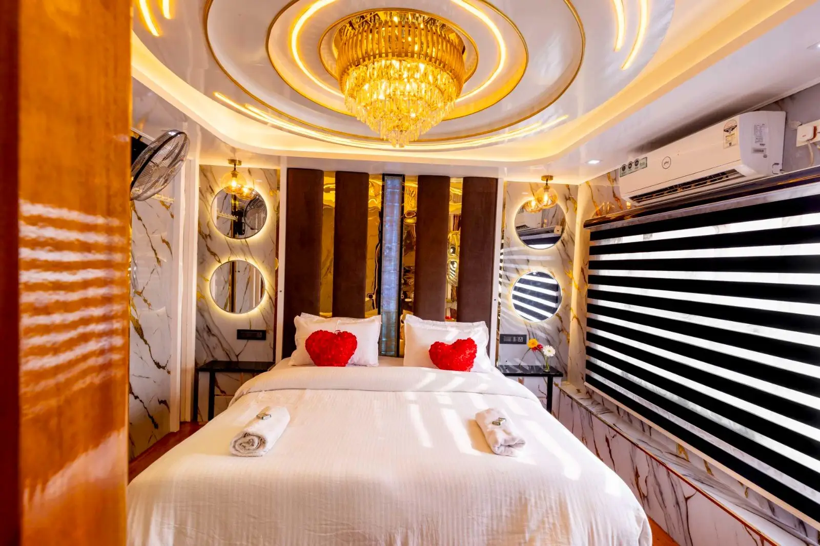 Honeymoon bed setup with heart cushions and chandelier on an Alleppey houseboat