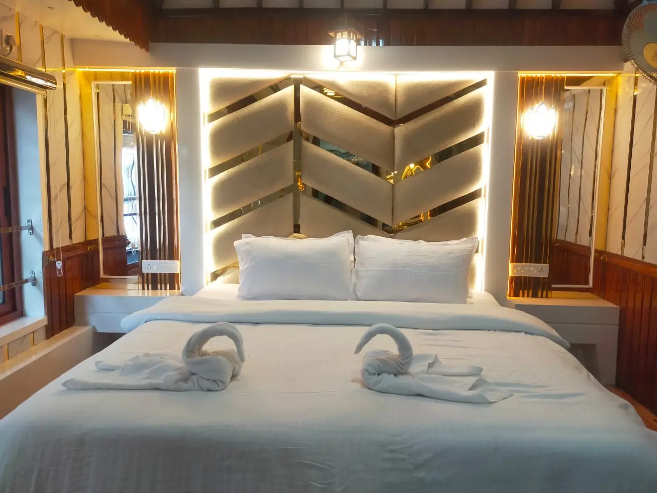 King bed with backlit headboard in a premium Alleppey houseboat bedroom