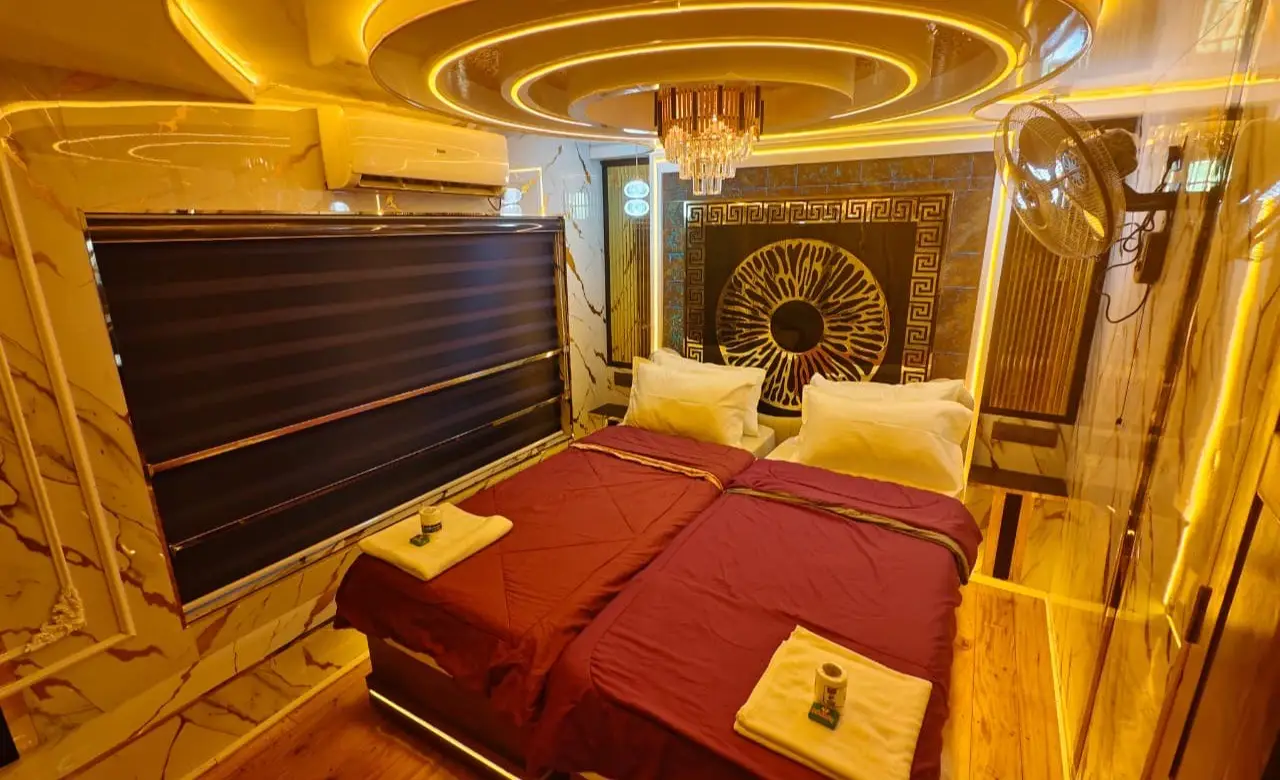 Air-conditioned double bedroom with mood lighting and carved headboard on an Alleppey houseboat