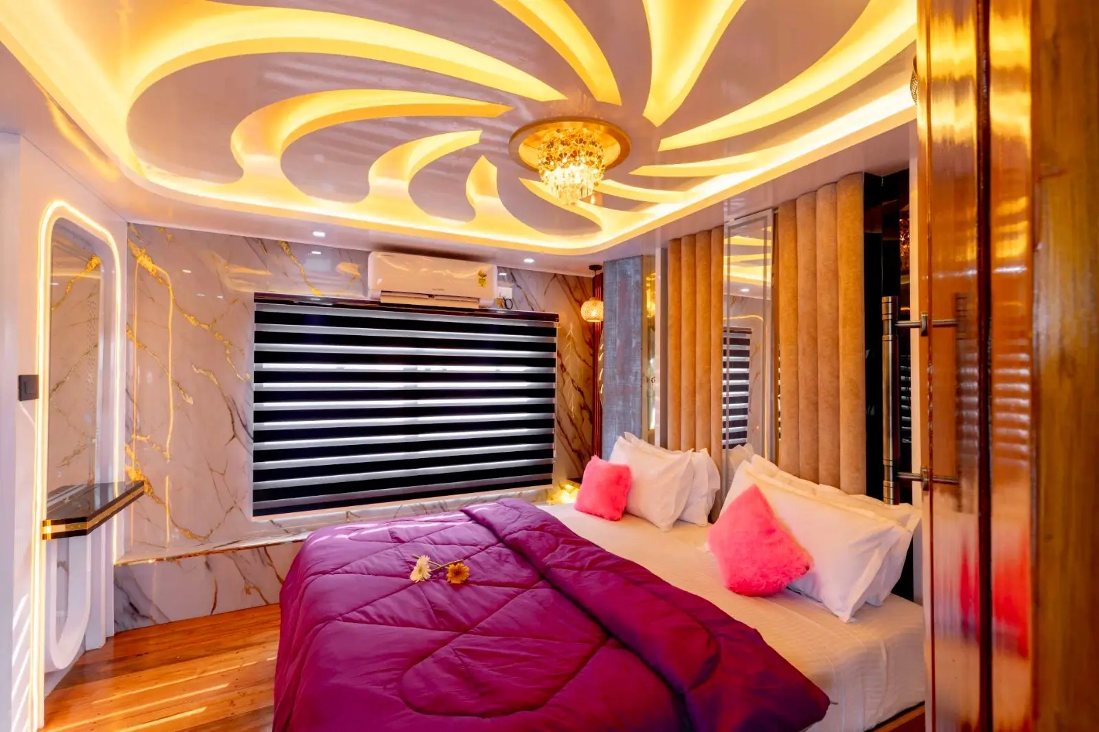 Second air-conditioned bedroom with decorative lit ceiling on a Kerala houseboat