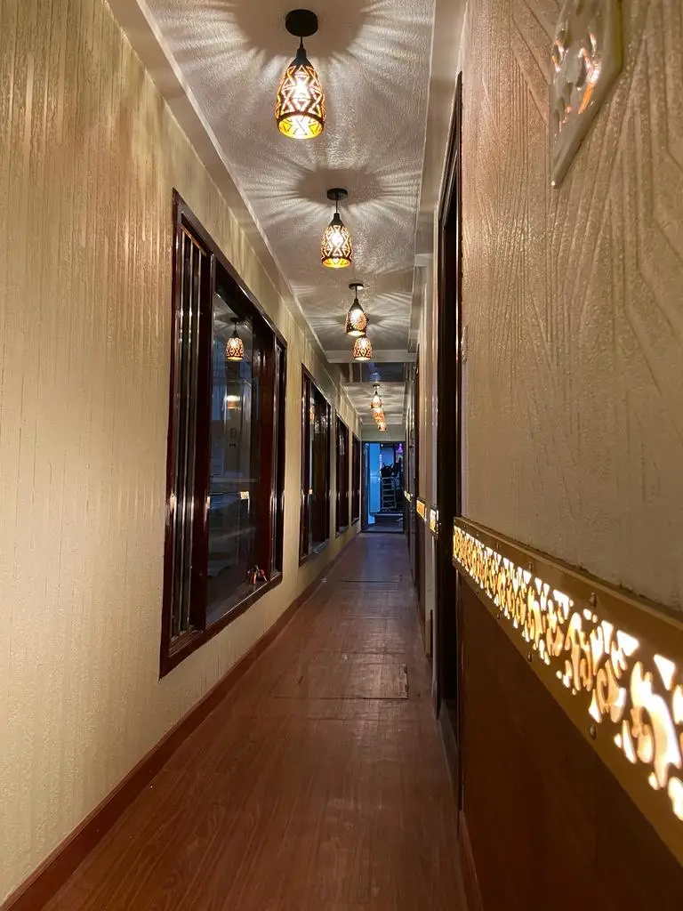 Corridor with ornate hanging lamps on an eight-bedroom Kerala houseboat