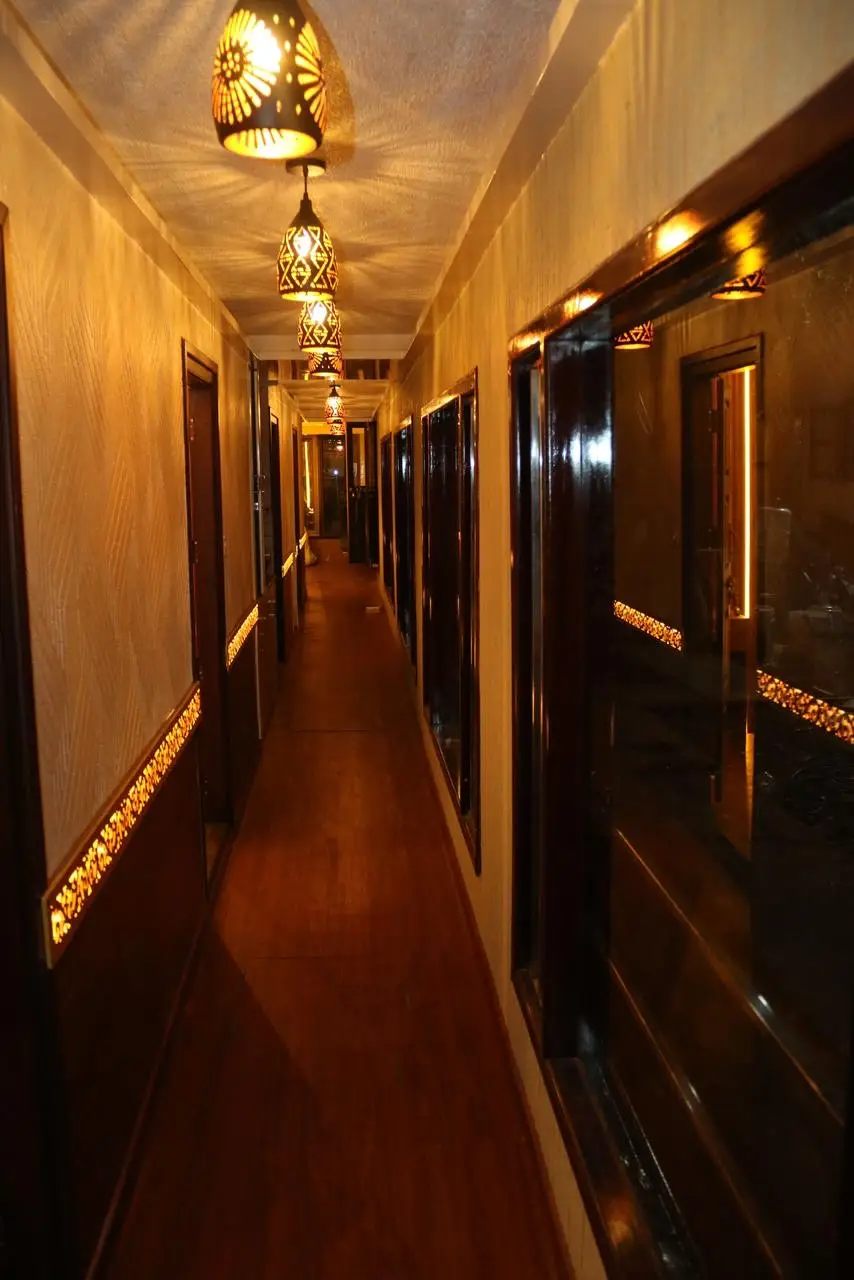 Lantern-lit corridor lined with bedroom doors on a large Alleppey houseboat