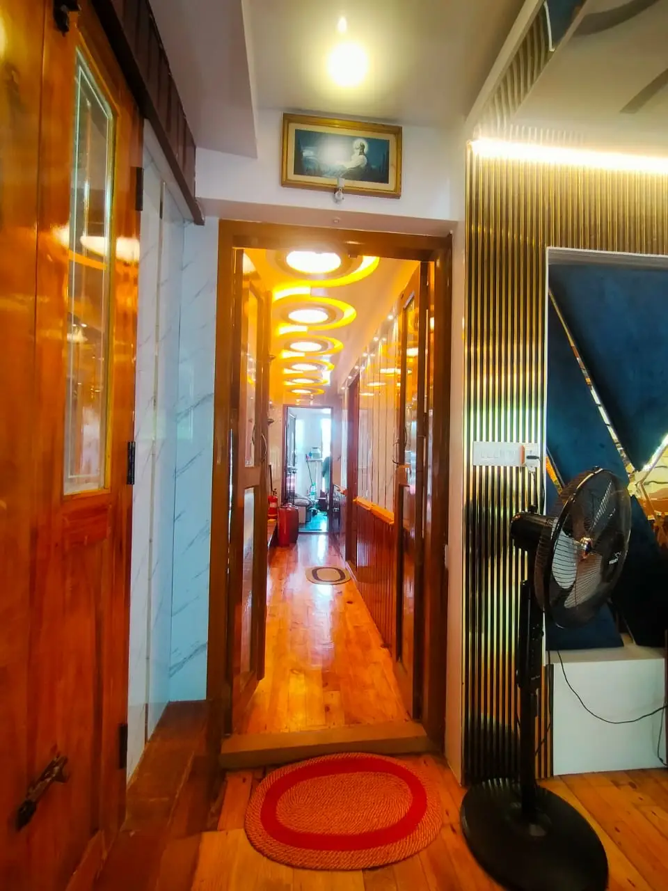 Lit interior corridor leading to the bedroom of a premium Alleppey houseboat