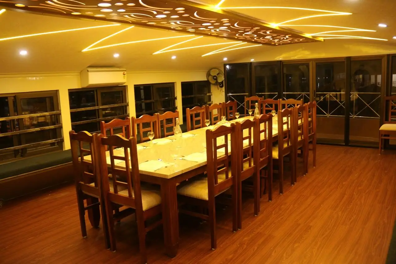 Banquet dining hall seating sixteen on an eight-bedroom Kerala houseboat