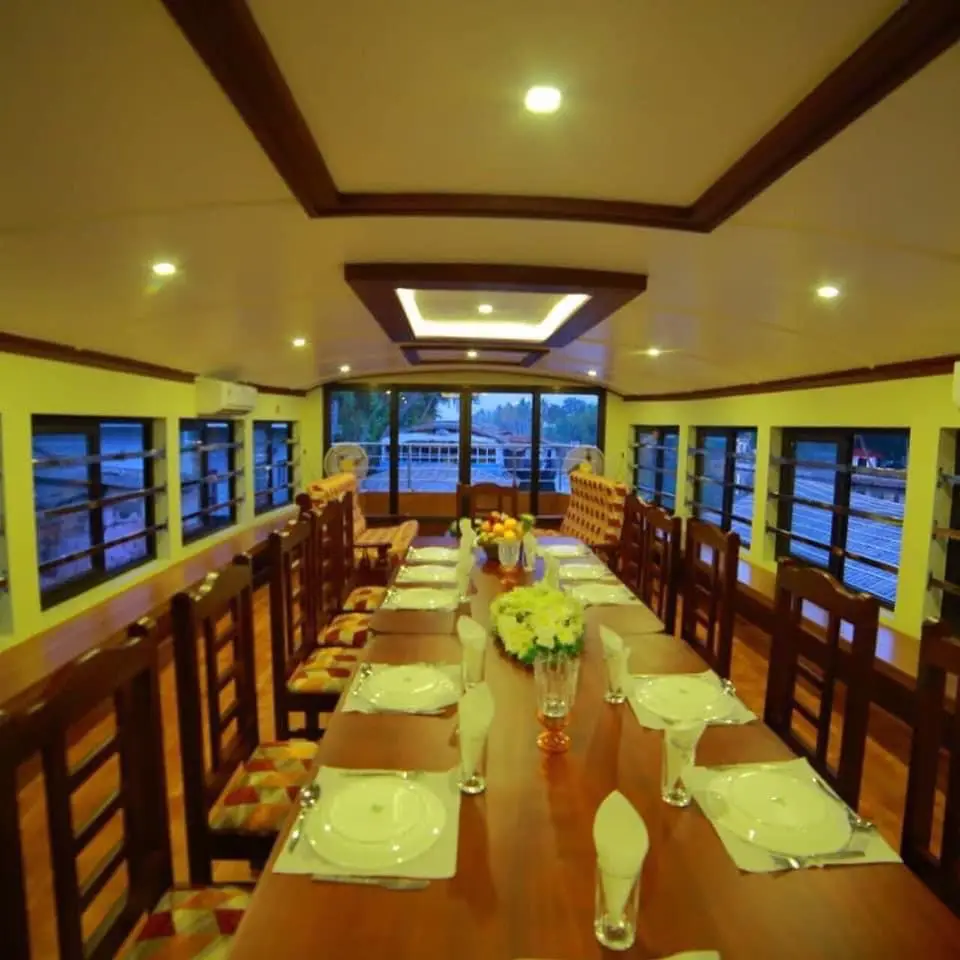Dining hall table set with crockery and flowers on an Alleppey group houseboat
