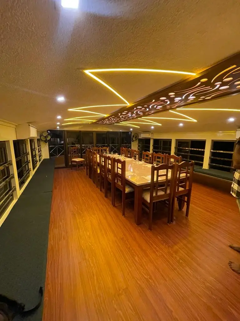 Wide view of the dining hall and deck seating on a large Kerala houseboat