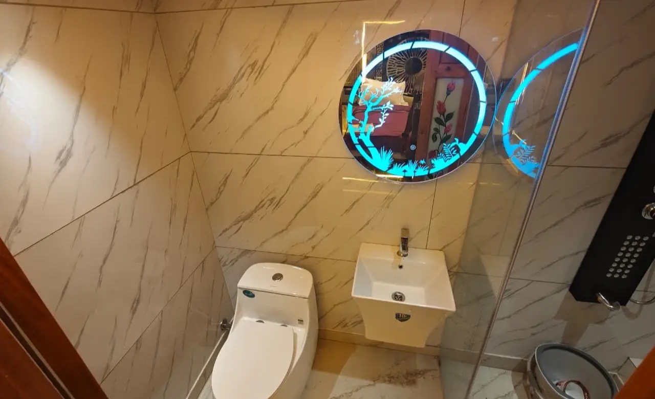 Wash basin and illuminated mirror in the en-suite bathroom of a premium houseboat