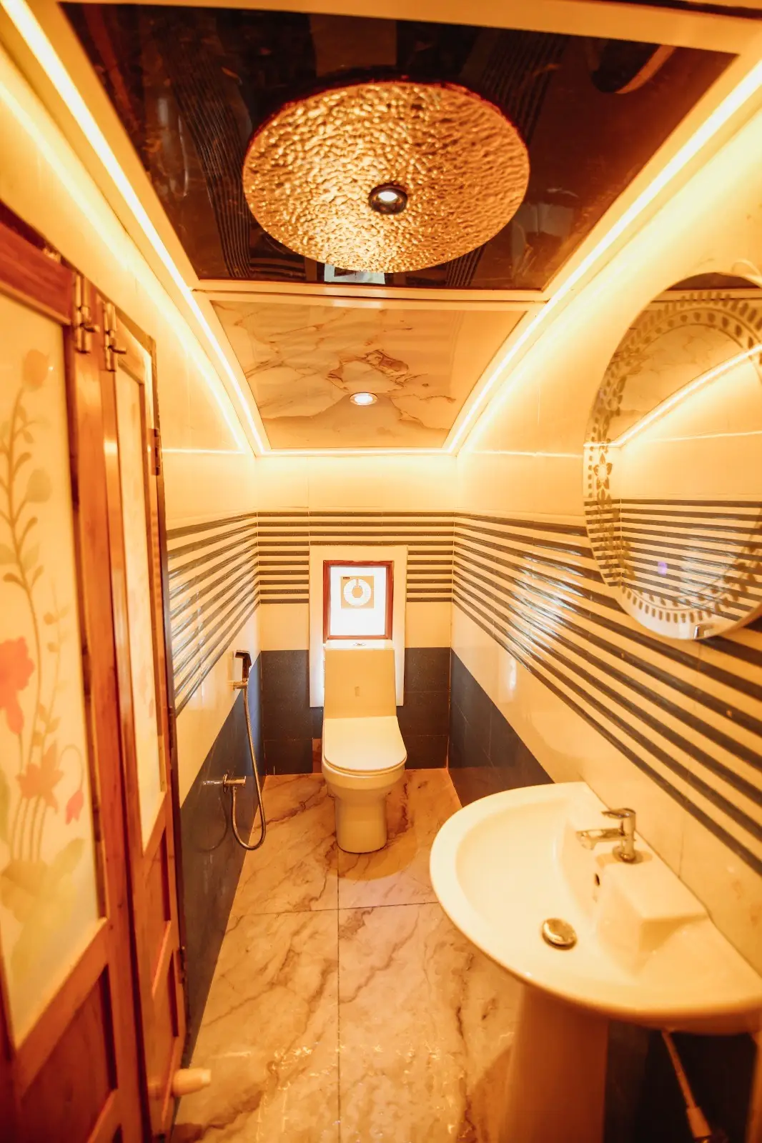Gold-finished en-suite bathroom with textured ceiling on an Alleppey houseboat