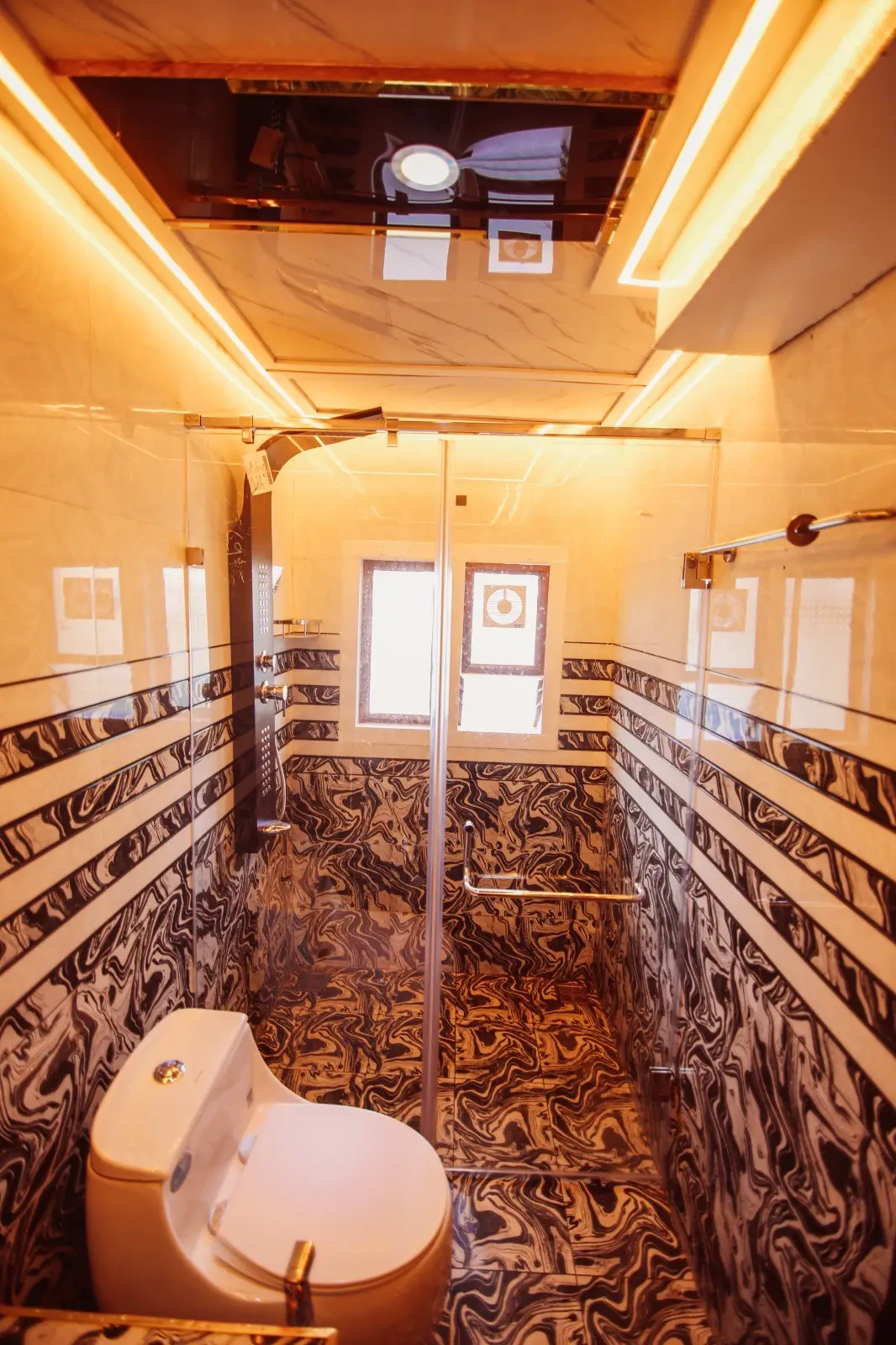 Glass rain-shower cubicle in a patterned marble bathroom on a luxury houseboat
