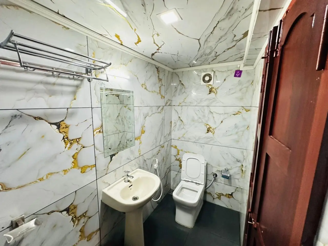 En-suite bathroom with marble tiling and towel rail on an Alleppey houseboat