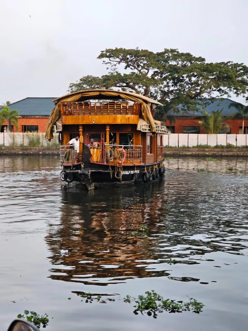 Front view of a one-bedroom Alleppey houseboat moored on a backwater canal