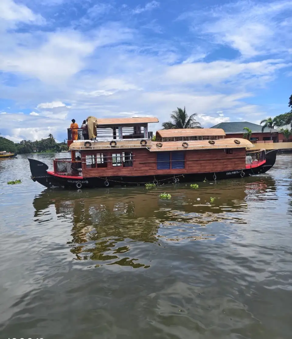 One-bedroom premium Alleppey houseboat cruising the Punnamada backwaters under a monsoon sky