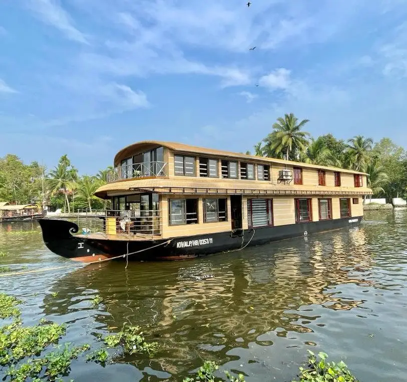 Eight-bedroom double-decker Alleppey houseboat cruising Vembanad lake under blue sky