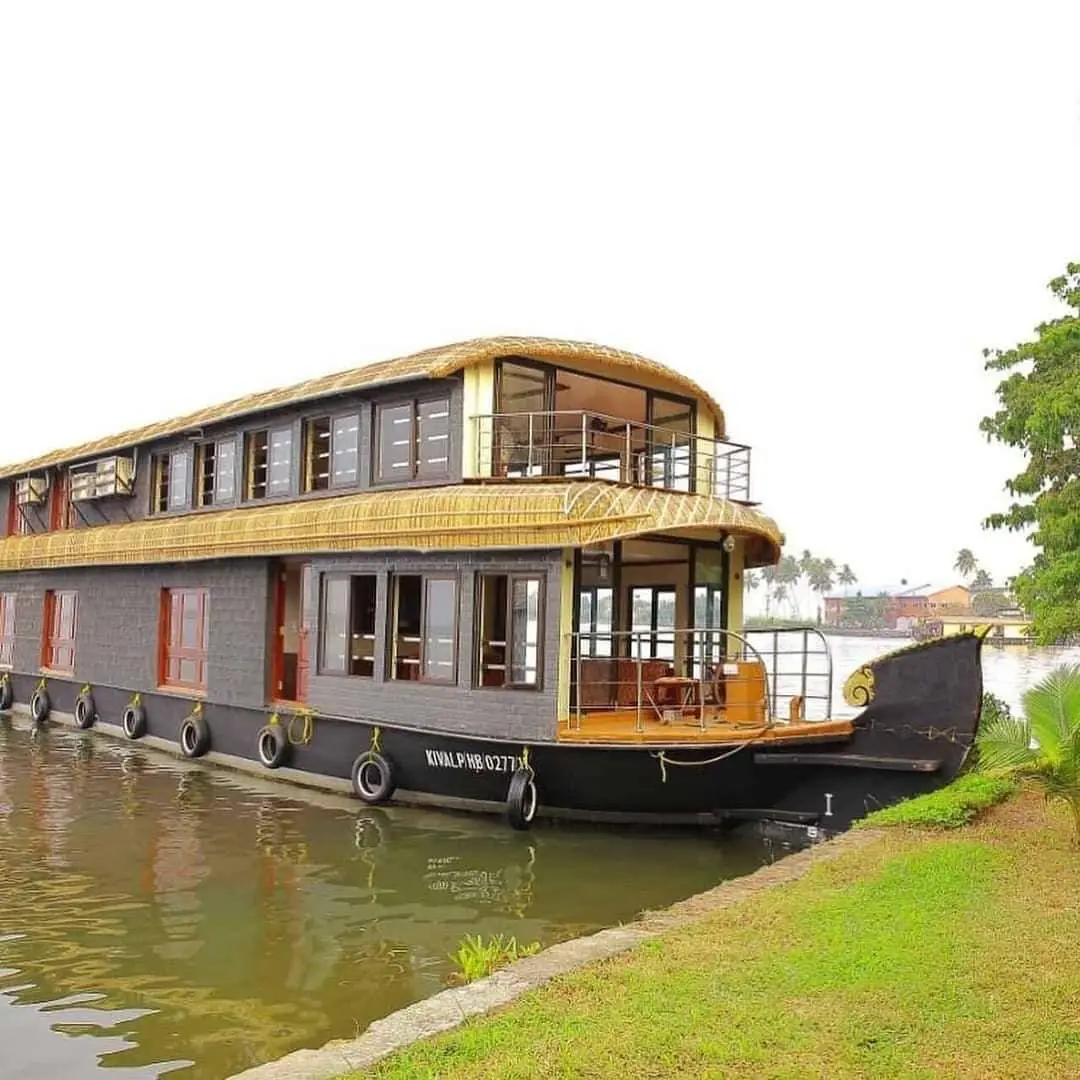 Six-bedroom double-decker Alleppey houseboat moored on a backwater canal bank