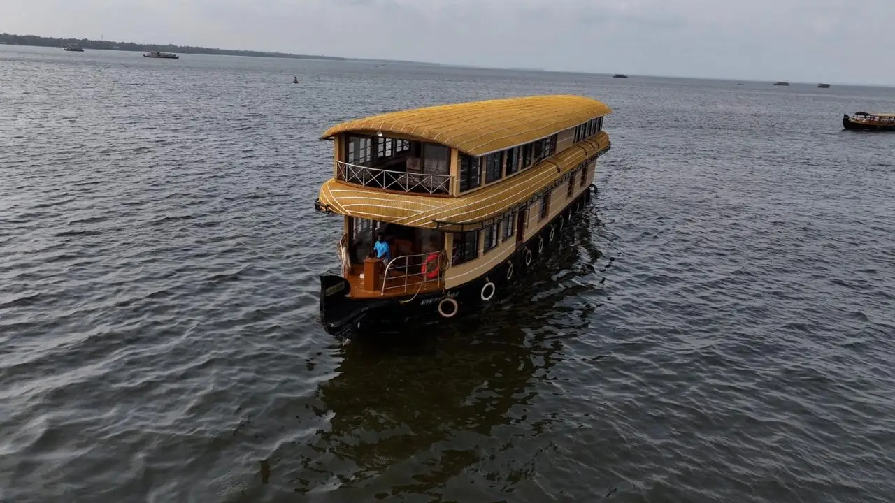 Four-bedroom double-decker Alleppey houseboat with thatched roof on Vembanad lake