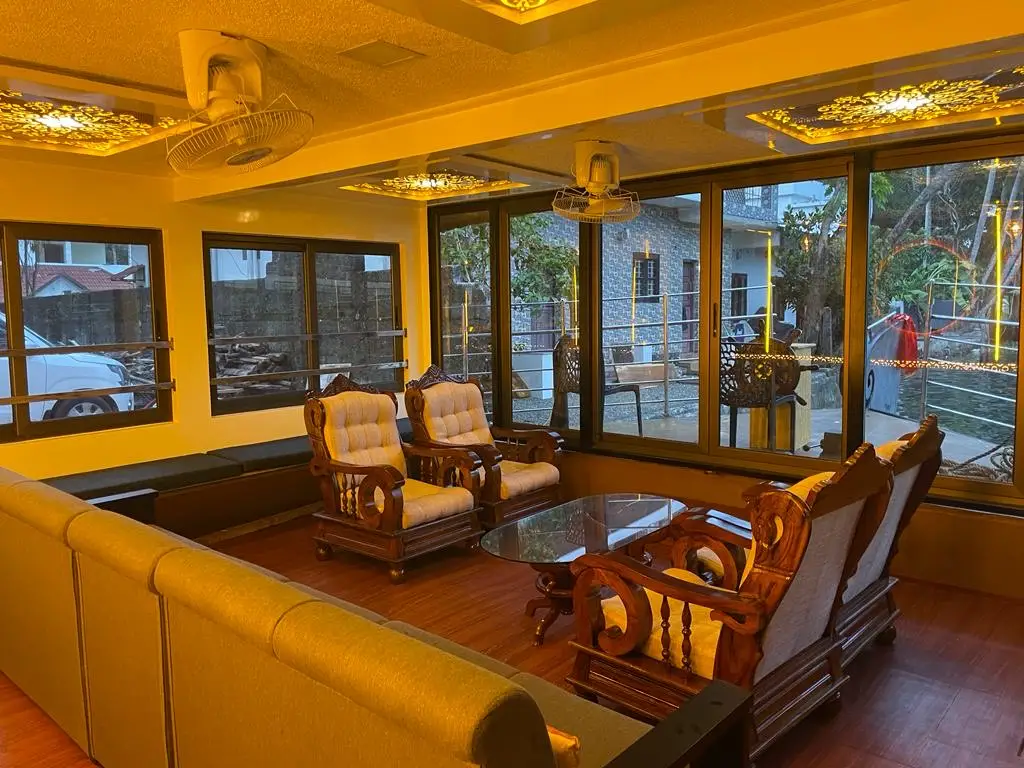 Evening lounge with carved teak armchairs and panoramic windows on a houseboat