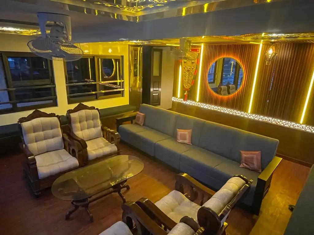 Lounge with feature lighting, long sofa and backlit panelling on an Alleppey houseboat