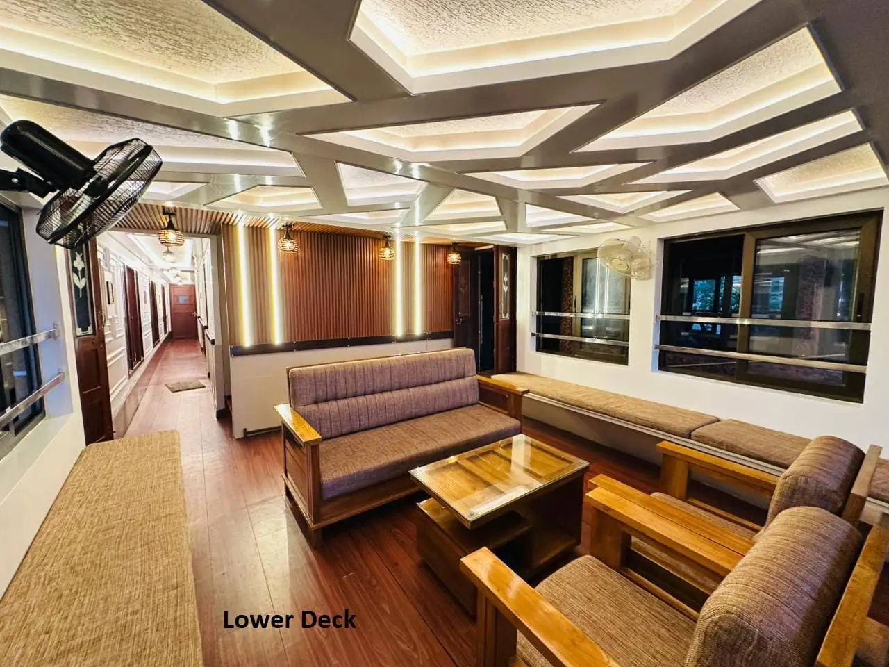 Sofa and armchair seating on the lower deck of a four-bedroom Kerala houseboat