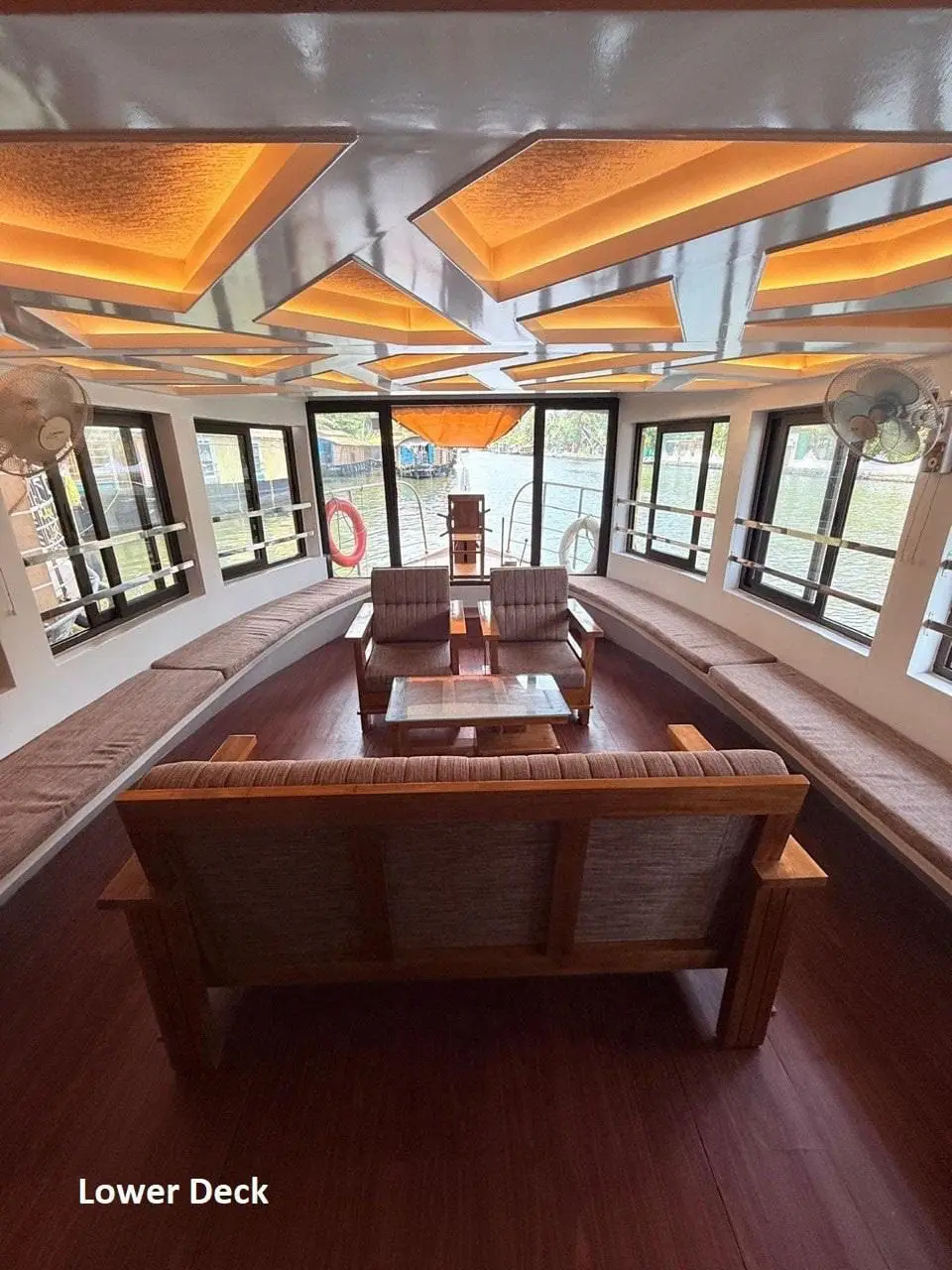 Wide lower deck lounge with bench seating along both sides of an Alleppey houseboat