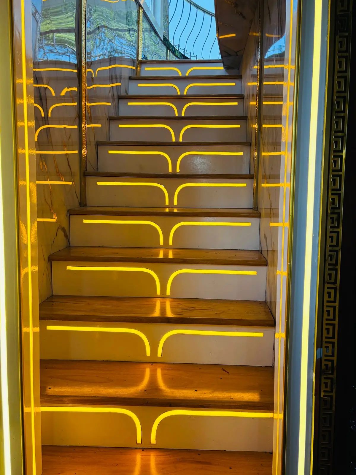 Backlit staircase treads leading to the upper deck of a luxury houseboat