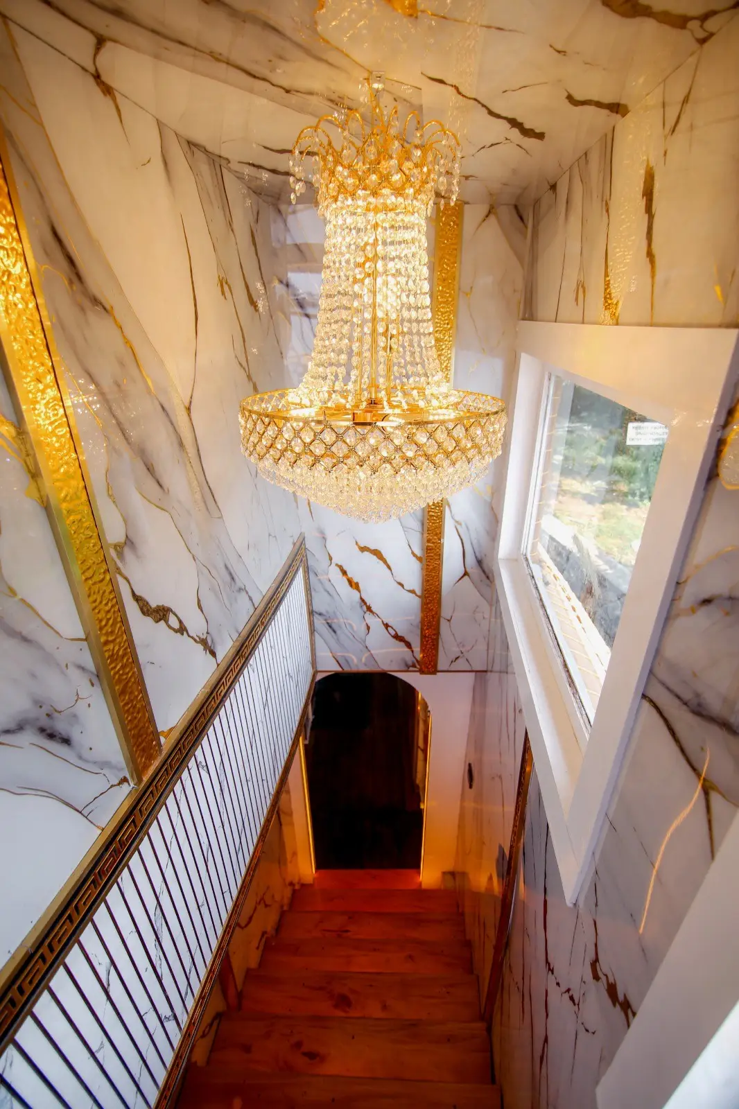 Marble stairwell with a tiered crystal chandelier on a luxury Alleppey houseboat