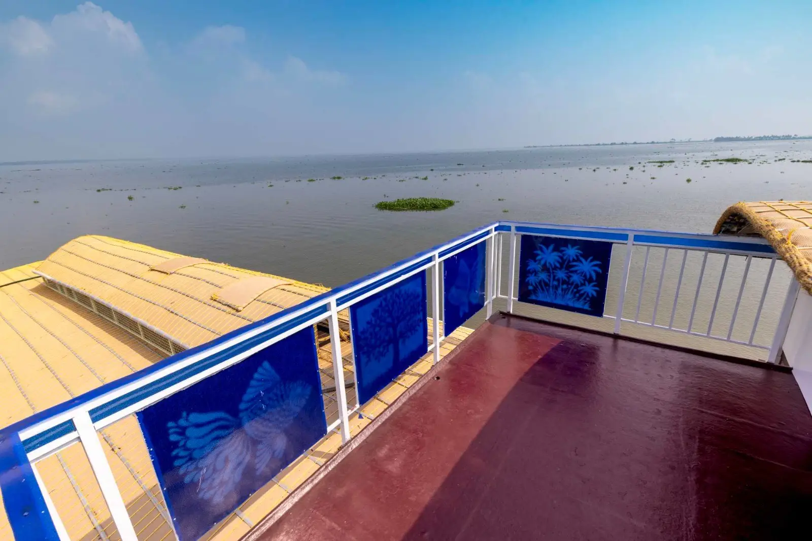 Open sundeck with painted rails looking across Vembanad lake