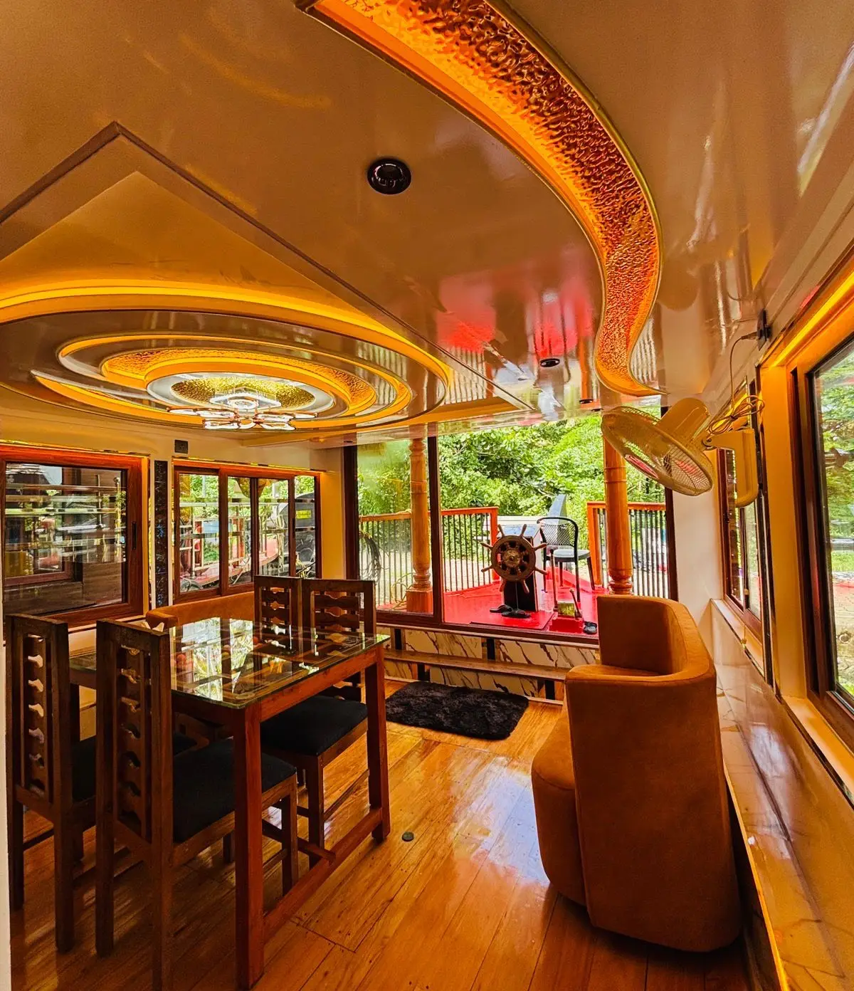 Upper deck dining table beside the open rail of a Kerala backwater houseboat