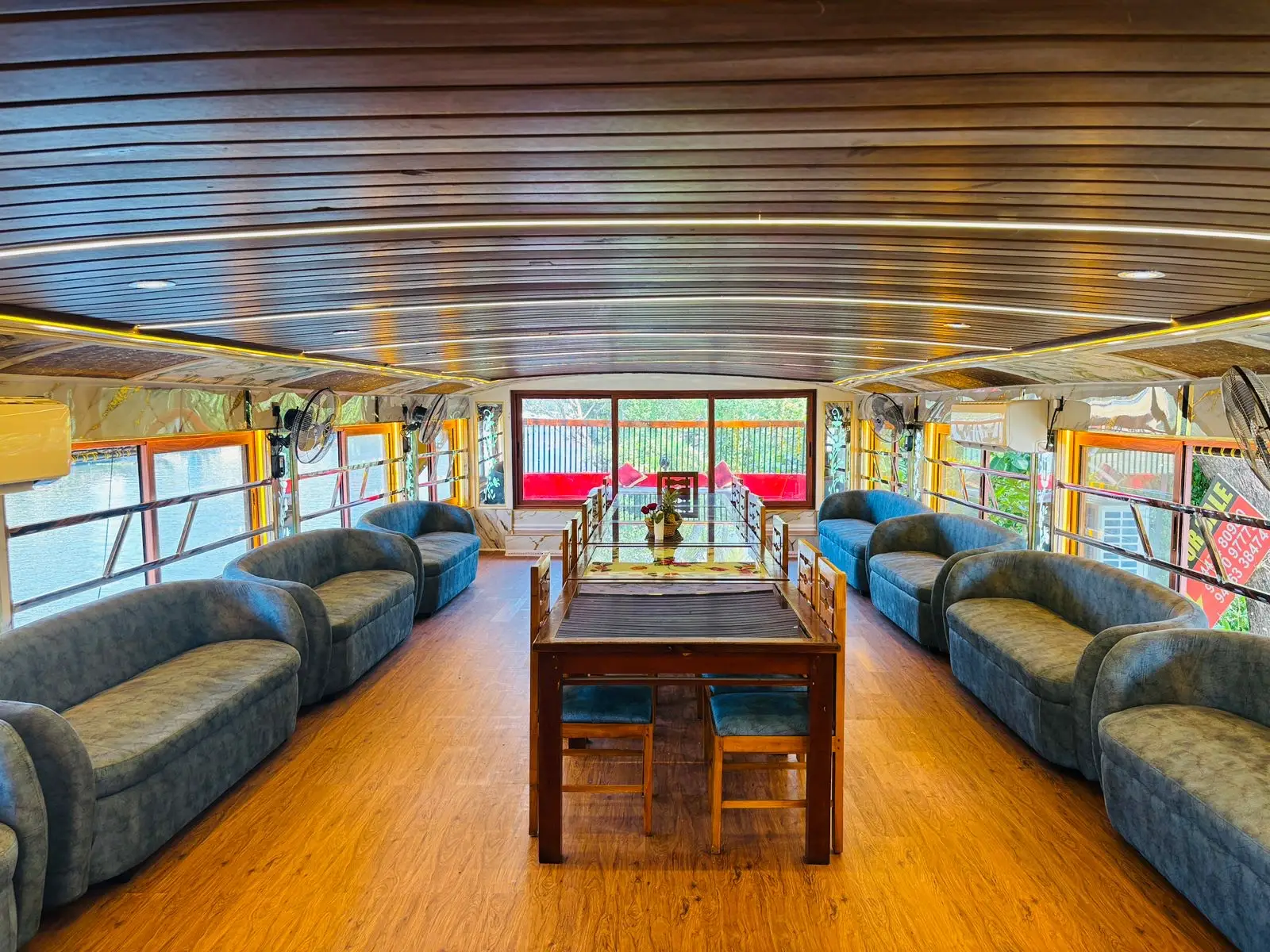 Upper deck dining table with sofa seating on a five-bedroom luxury houseboat