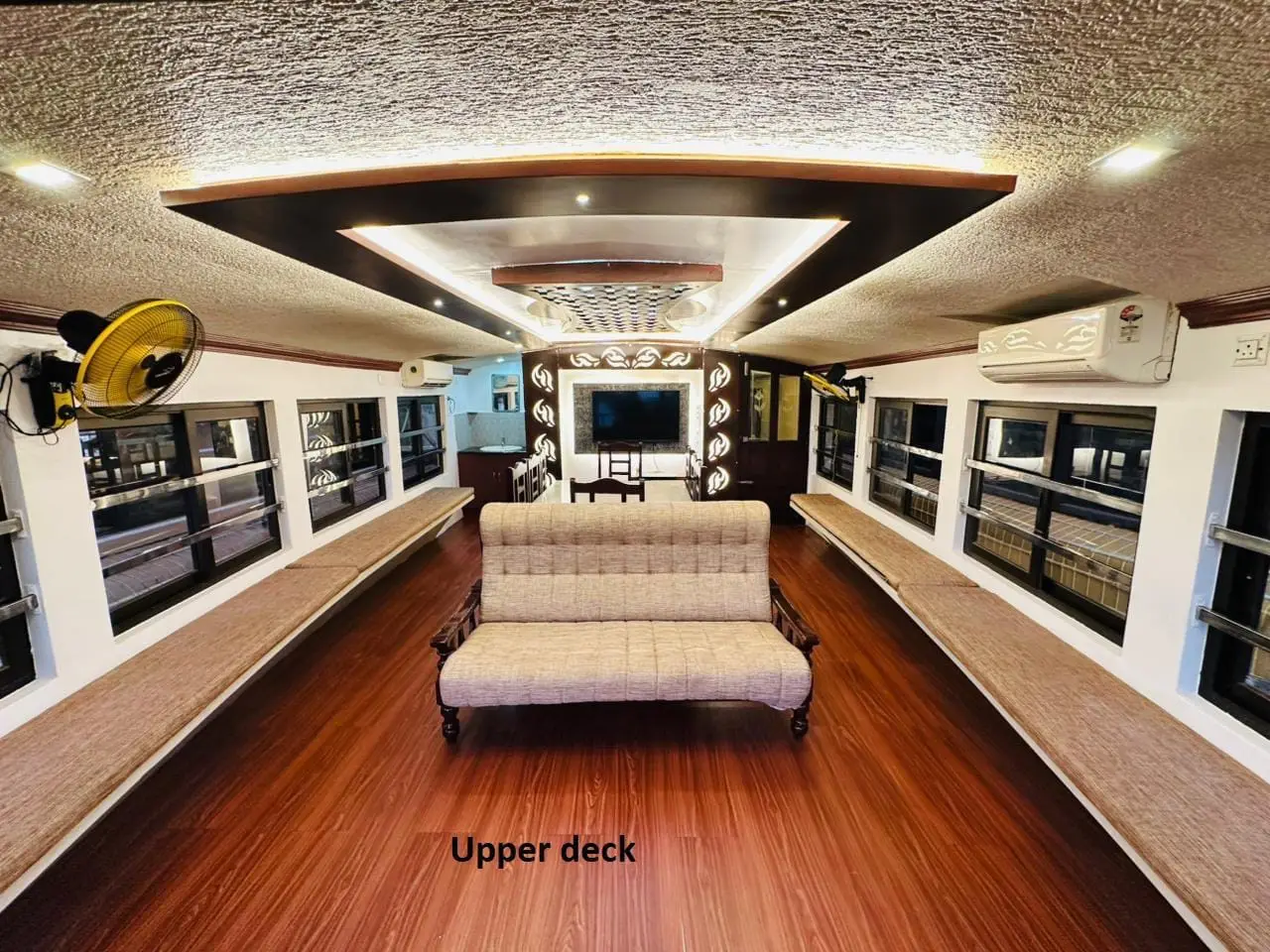 Upper deck sitting area with television and wraparound bench seating
