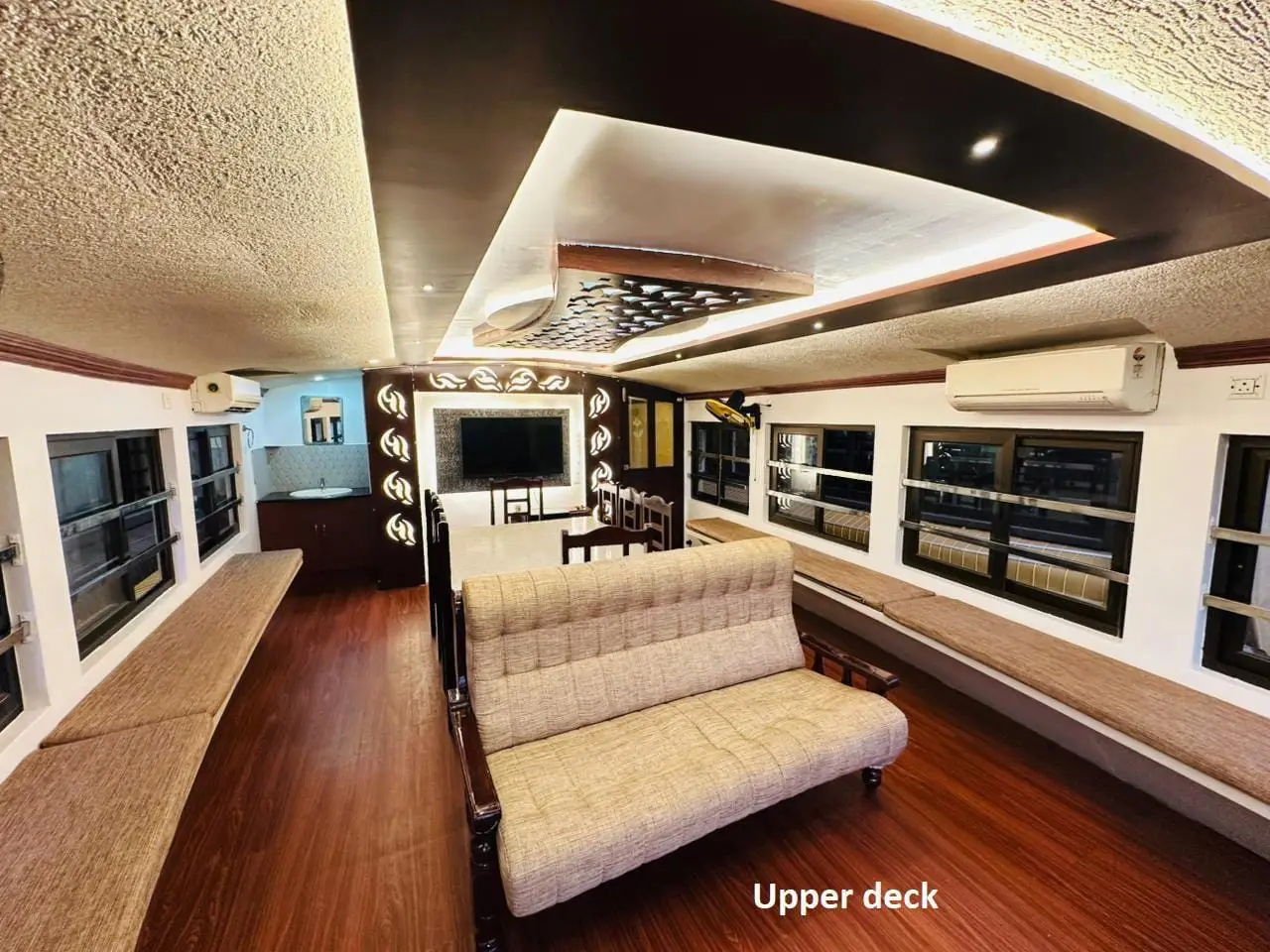 Upper deck lounge with sofa, television and air conditioning on a premium houseboat