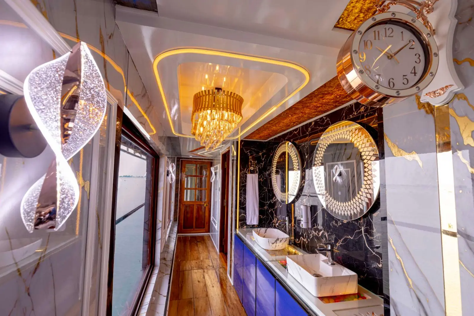 Marble vanity corridor with chandeliers and gold-framed mirrors on a Kerala houseboat